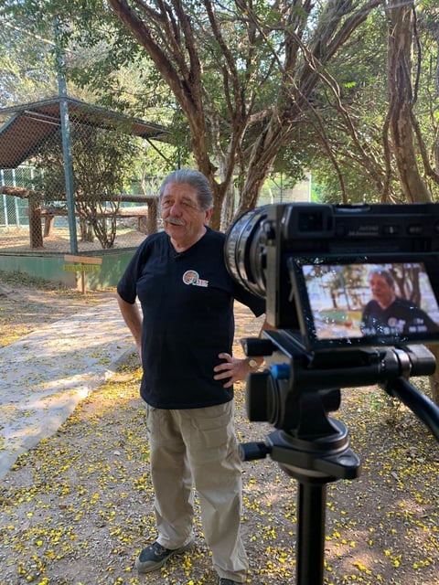 Man in black shirt being filmed outdoors